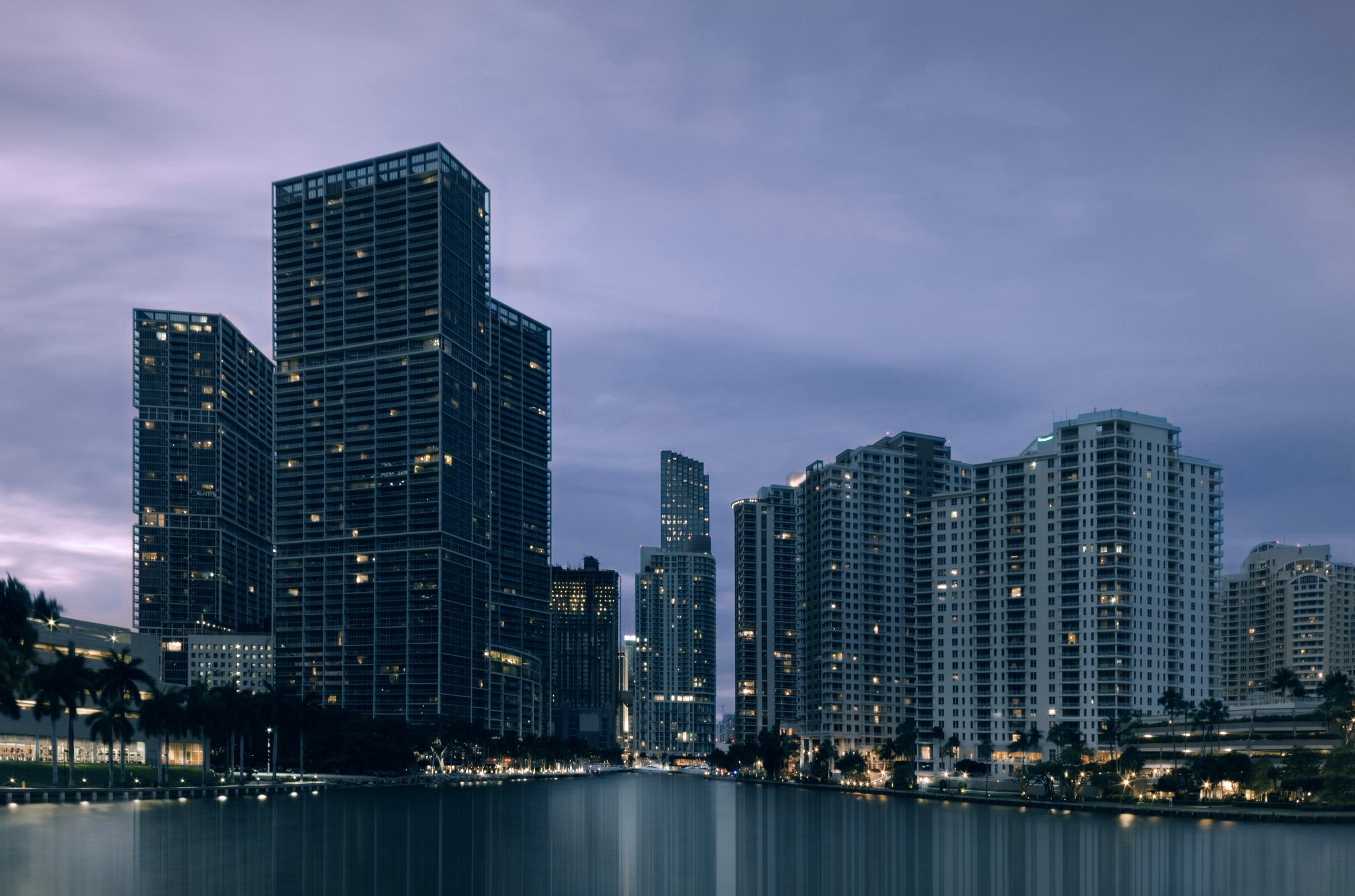 Brickell Key towers reflected in the water at dusk